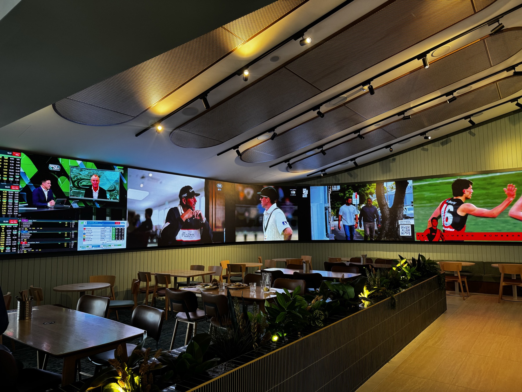 The same ribbon in sports mode: a row of live sports feeds and a scores panel over the dining tables