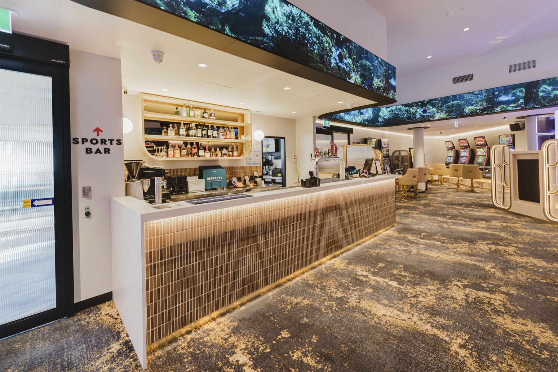 The bar under the LED ribbon, the rainforest scene continuing overhead into the gaming room