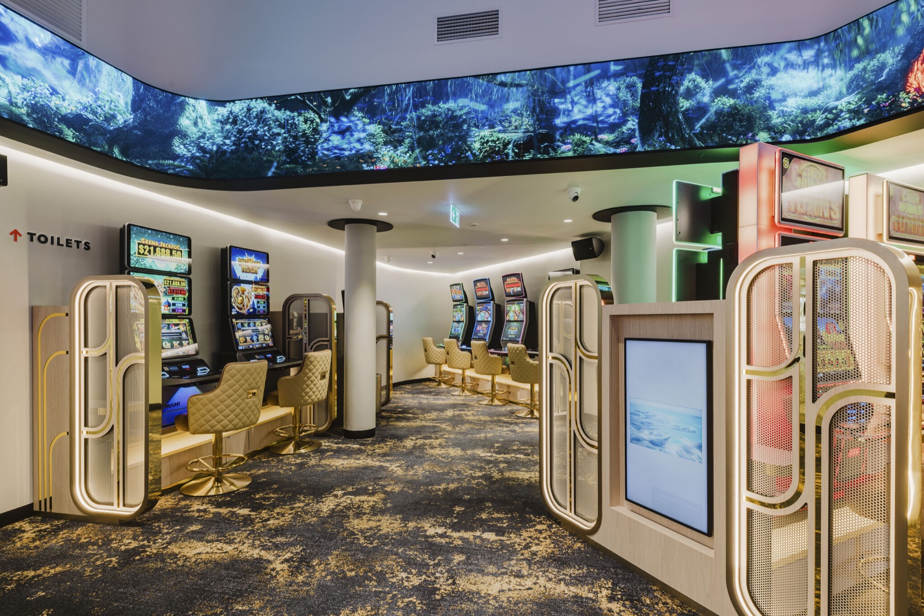 Inside the gaming room: the LED ribbon wrapping the ceiling above the machines, mesh screens and a column